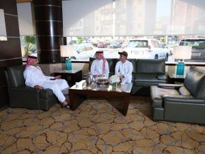 科威特Boudl AL Salmiya بودل الكويت السالمية的三人坐在客厅里