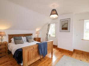 CarrigartLough View Cottage的一间卧室配有一张大木床。