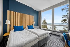 科林基拉科利布雷克索科斯酒店的一间卧室设有一张大床,拥有蓝色的墙壁和窗户。