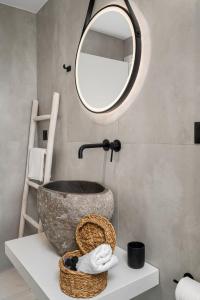 莫拉托斯Milatos Seaside Suites的一间带石制水槽和镜子的浴室