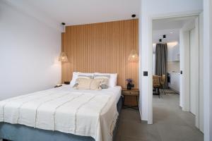 莫拉托斯Milatos Seaside Suites的卧室设有一张白色大床和一个走廊