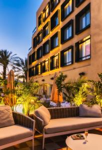 埃拉特Brown Eilat a member of Brown Hotels的带沙发的酒店庭院和大楼