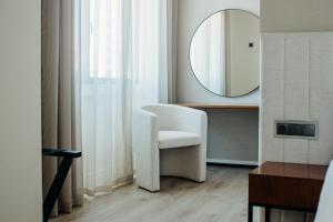 里斯本Next Level Premium Hotels的浴室设有白色椅子和镜子