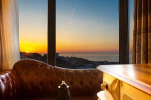 特拉布宗Andalouse Elegant Suite Hotel的窗户前的沙发,享有日落美景