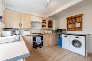 切尔滕纳姆Luxury Cheltenham Home with EV charger - Lechampton Hills的厨房配有洗衣机和洗衣机。