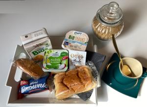 富瓦Studio Le Flore - Petit déjeuner inclus 1ère nuit - AUX 4 LOGIS的午餐盒,带三明治和面包,以及一杯咖啡