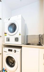 墨尔本Stylish Urban Oasis的厨房配有洗衣机和微波炉。