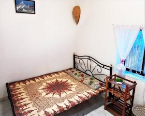 卡纳科纳Cockerel Homestay - Traditional Beach Village - Goa的小卧室配有一张铺着地毯的床