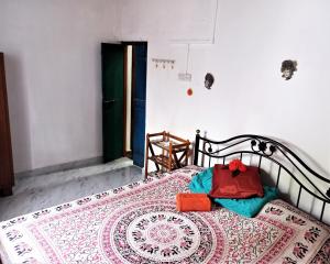 卡纳科纳Cockerel Homestay - Traditional Beach Village - Goa的一间卧室配有一张铺着地毯的床