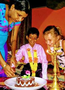 卡纳科纳Cockerel Homestay - Traditional Beach Village - Goa的女人与孩子切成蛋糕