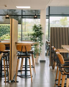 兰斯比萨尼斯兰斯安客市瑞姆斯酒店的餐厅设有桌椅和窗户。