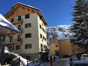 瓦卢瓦尔Appartement Valloire, 4 pièces, 9 personnes - FR-1-263-216的树旁的雪地建筑