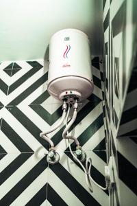 斋浦尔Pachamama Hostel的浴室内的一个吹风机,铺有黑白的地板