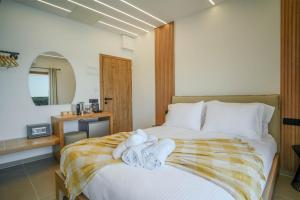 帕尔加Omnia Deluxe Rooms的一间卧室配有带毛巾的床