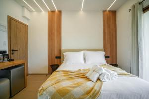帕尔加Omnia Deluxe Rooms的一间卧室配有带毛巾的床