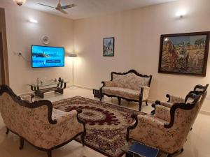 戴尔豪斯BluSalzz Villas - The Pine Tree, Dalhousie - Himachal Pradesh的客厅配有两把椅子和电视