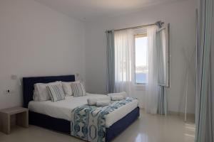 奥诺斯Amaris Mykonian Residence的白色的卧室设有一张大床和一个窗户