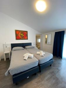 托尔博莱Hotel Aurora & Appartamenti的一间卧室配有两张带毛巾的床