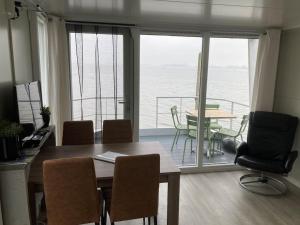 比丁赫伊曾Houseboot Cormorant, lake view的一间设有桌子的海景用餐室