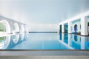 蒙塔鲍尔蒙塔鲍尔城堡酒店的一座游泳池,位于一栋设有蓝色地板和窗户的建筑内