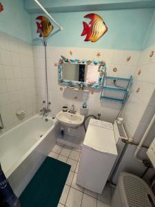 考波什堡Orange Apartman的浴室配有盥洗盆、浴缸、卫生间和盥洗盆。