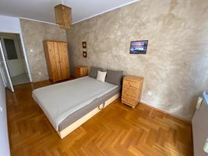 考波什堡Orange Apartman的一间卧室设有一张大床,铺有木地板