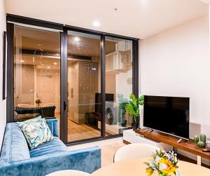墨尔本Stylish Urban Oasis的客厅配有蓝色的沙发和电视