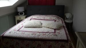 Saint-Martin-Saint-FirminLe Petit Château的一间卧室配有一张带粉色和白色被子的床