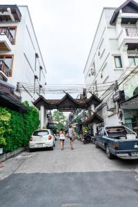 清迈Chiang mai Walking Street Home ( เชียงใหม่วอล์คกิ้งสตรีทโฮม )的几个人开车沿着街道走