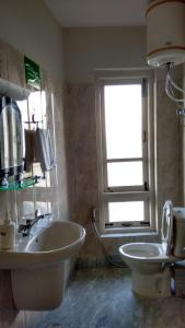 噶伦堡玉如德乐旅馆的一间带水槽和卫生间的浴室以及窗户。