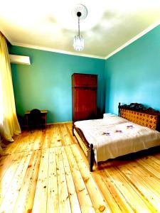 巴统Дом с 5 спальнями в Батуми的一间卧室配有一张床,铺有木地板
