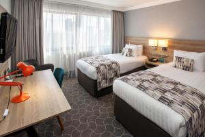 普雷斯顿假日普雷斯顿酒店的酒店客房设有两张床和一张桌子。