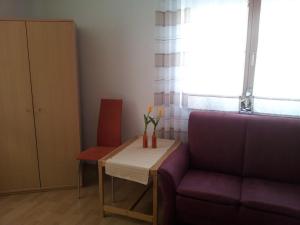 萨尔堡Ferienwohnung Wilhelmi的客厅配有桌子和紫色沙发