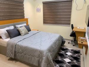 哈科特港Rehoboth Homes的一间卧室配有一张床、一张书桌和一台电视