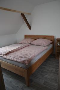 因德日赫城堡Penzion Mezi řádky的卧室内的一张床铺,配有木制床架