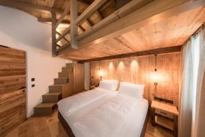卡纳泽伊Rifugio Salei的卧室配有白色的床和楼梯。