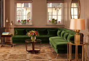 伦敦Flemings Mayfair - Small Luxury Hotel of the World的客厅配有绿色沙发和2张桌子