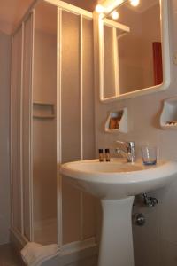 塔兰托广场酒店的一间带水槽、镜子和淋浴的浴室