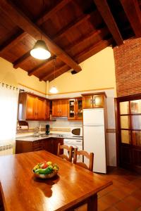 坎德拉里奥Casa Rural Puerta del Sol de 3 habitaciones的厨房配有木桌,上面放着一碗水果