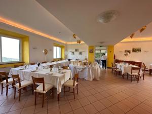 拉帕洛Hotel Montallegro的宴会厅配有白色的桌椅
