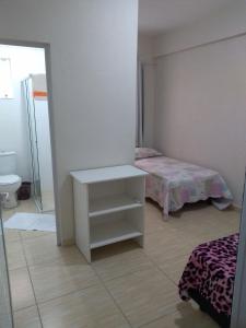伊塔佩马Pousada Batista的一间卧室配有一张床、一张桌子和一面镜子