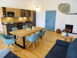 HuglfingGut Grasleiten的厨房以及带木桌和椅子的客厅。