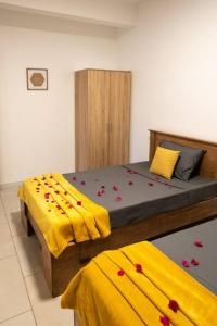 Coteau RaffinLe Rivage Appartement Mauritius的一间卧室配有两张红色鲜花的床。