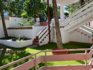 斯塔多伊兰Aqualux Apartments的树的院子中的白色楼梯