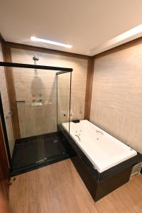 贝伦金塔石中庭酒店的带浴缸和玻璃淋浴间的浴室。