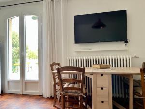 格雷乌莱班Gite Harmonie的客厅配有桌子和墙上的电视