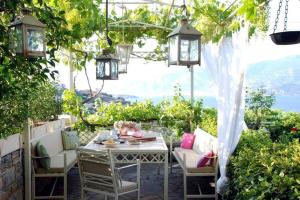 沃洛斯Evelina - Home with View的户外庭院配有桌椅和灯