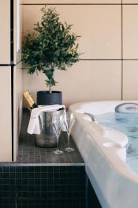 切斯特菲尔德卡萨酒店的浴缸配有两杯酒和盆栽植物