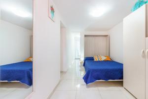 普罗奇达casetta mariapia的白色客房的两张床,配有蓝色的床单