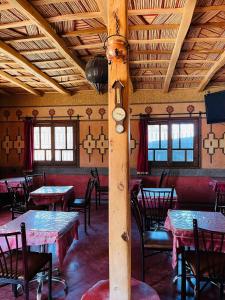 凯拉Kasbah Tialouite的用餐室设有桌椅和木制天花板